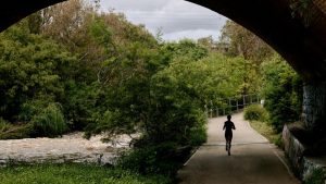 Person running under a bridge